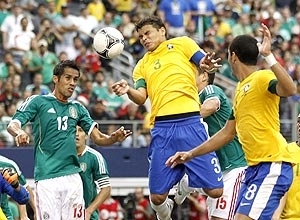 Thiago Silva cabeceia a bola observado pelo mexicano Corona
