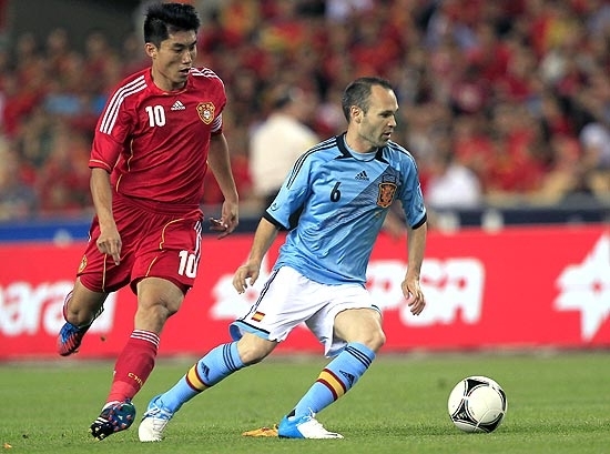 Andrs Iniesta domina a bola marcado por Zheng Zhi, da China, em amistoso em Sevilha
