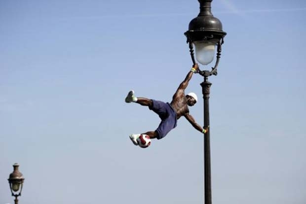 Acrobata fez malabarismos em poste de luz em Paris.