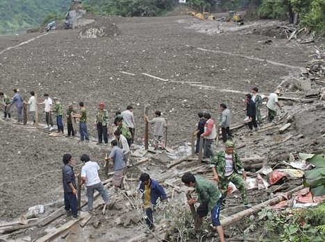 Pessoas buscam sobreviventes no vilarejo de Puladi soterrado pelos deslizamentos desta quarta-feira