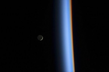 Lua crescente  vista  esquerda, ao lado da luz que atravessa a atmosfera em cores diferentes  direita