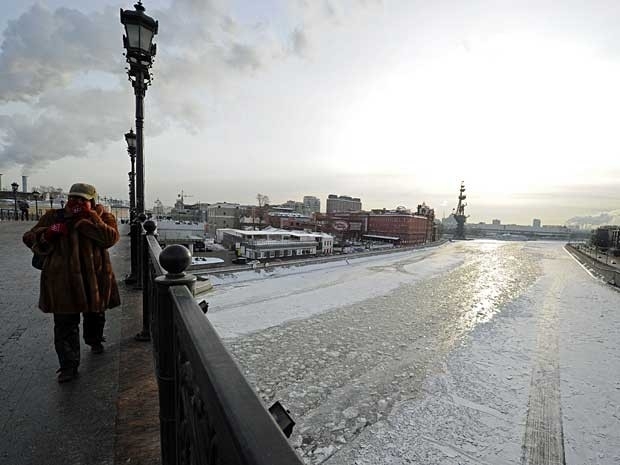 Uma mulher caminha pela ponte Patriarshy, que passa sobre rio congelado no Centro de Moscou.