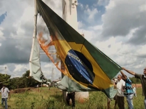 Produtores ateiam fogo  bandeira nacional em protesto  desocupao de Mariwatsd (Foto: Reproduo/TVCA)