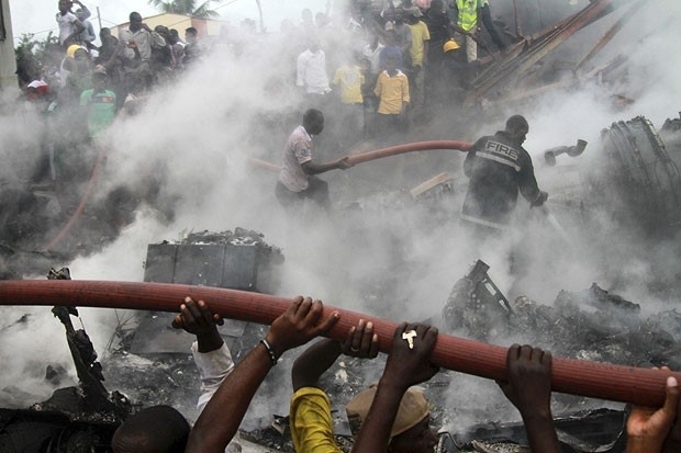 Nigerianos tentam apagar incndio em local onde ocorreu acidente areo, na cidade de