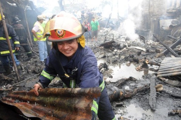 Bombeiro retira pedao de teto de local onde avio caiu em favela de Manila, nas Filipinas, neste sbado (10)