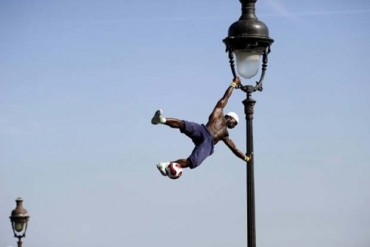 Acrobata fez malabarismos em poste de luz em Paris. 