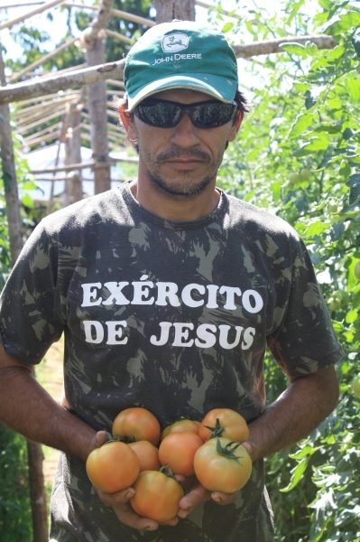 O produtor Jlio Carlos Rosa segura orgulhoso os tomates ao lado de sua produo.