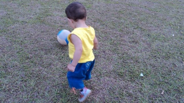 Bruninho brinca com uma bola em campo de futebol