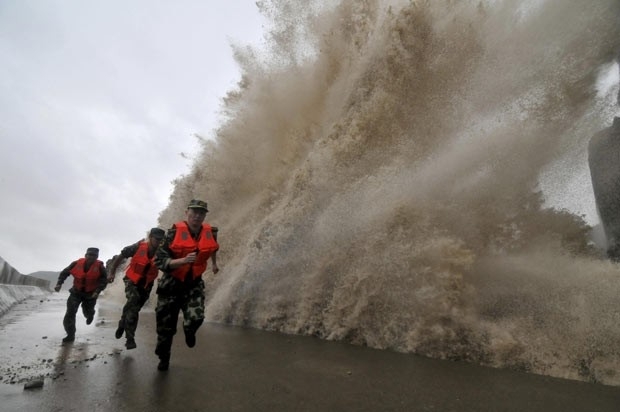 Guardas de fronteira fogem de onda gigante na costa durante a aproximao do tufo Fitow, em Wenling, na provncia de Zh