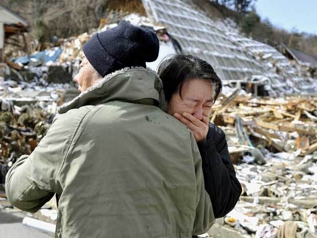 Mulher chora aps o corpo de sua me ser encontrado em rea devastada em Onagawa, Miyagi.