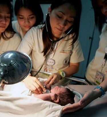 Mdicas do aeroporto de Manila, nas Filipinas, examinam neste domingo (12) o beb abandonado em um avio.